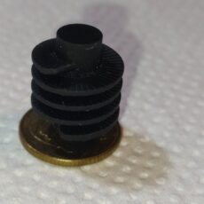 niewielki i wielowarstwowy detal z czarnego filamentu 3D- element w kształcie karbowanego walca w 3D-- promocjepolska